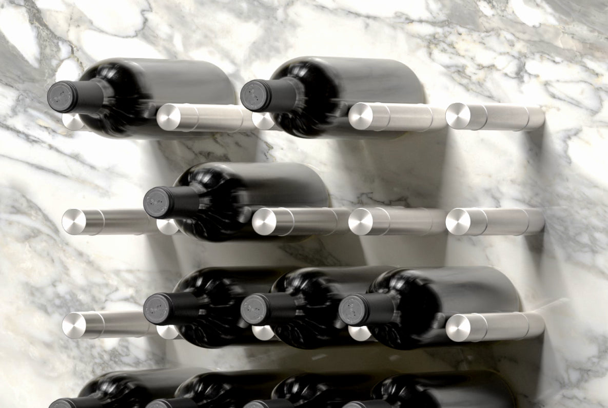 Wall-mounted metal wine bottle holders by Wine Pegs displaying 12 bottles on a marble wall