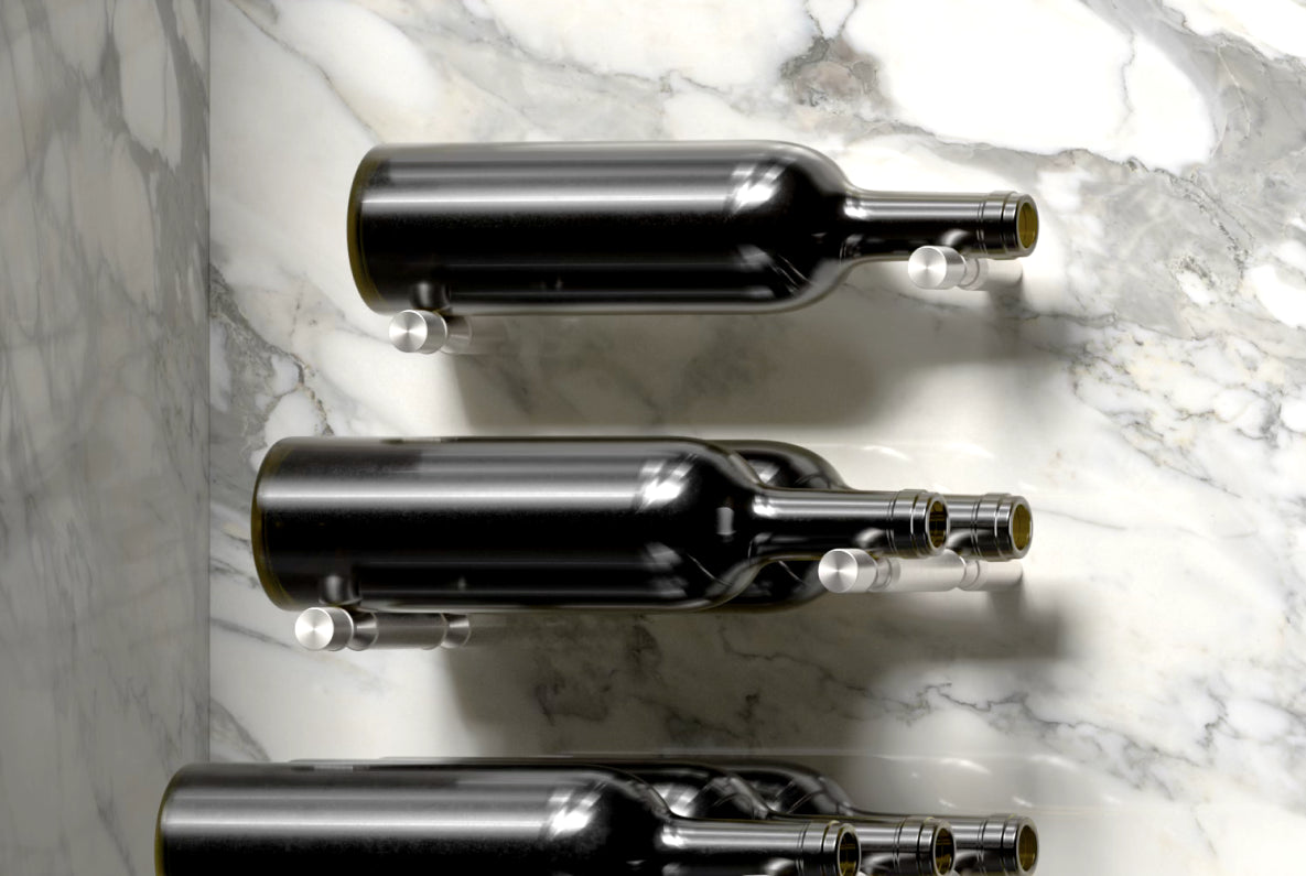 Metal wine bottle holders by Wine Pegs, displaying three bottles horizontally mounted to a marble wall